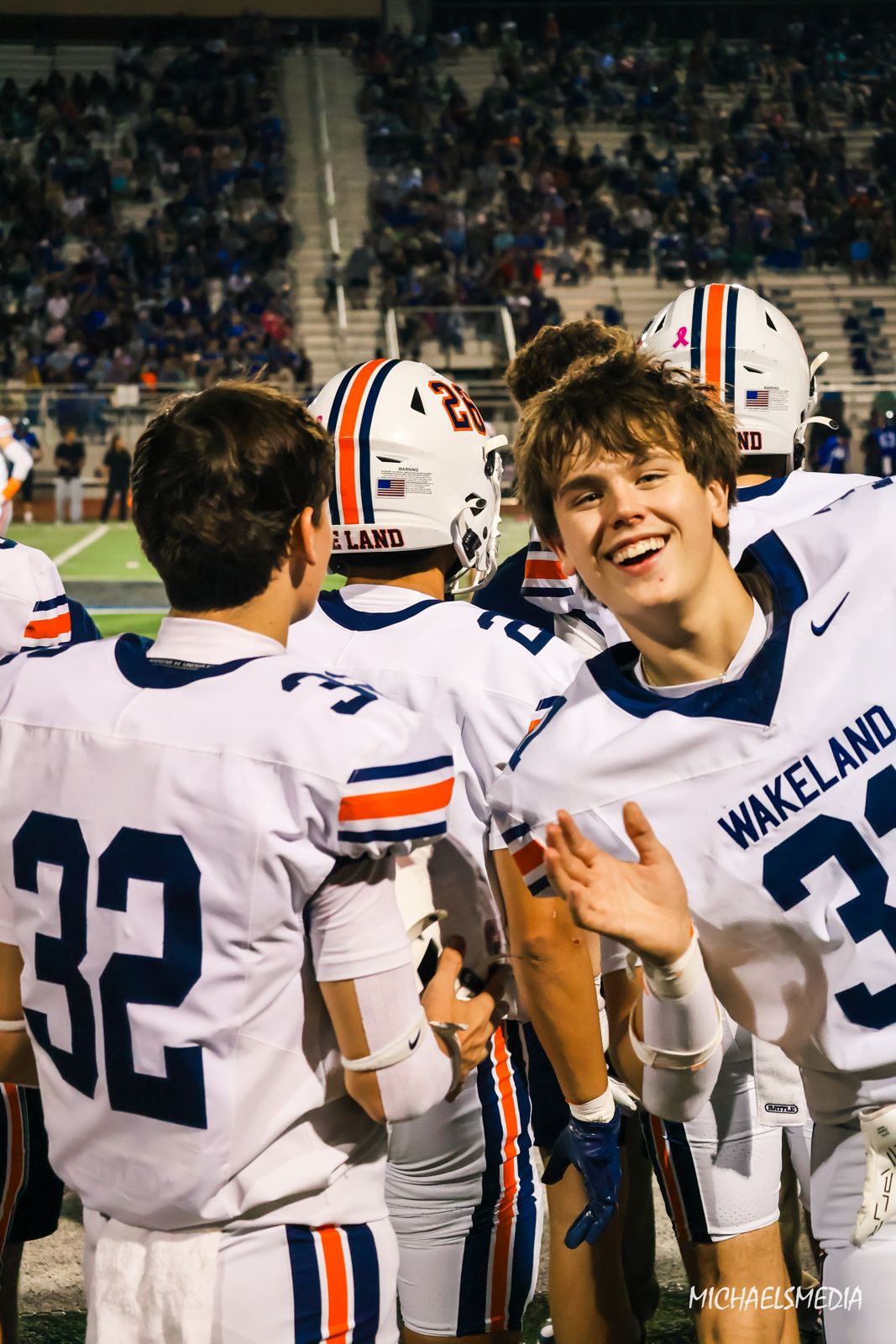 Wakeland teammates laughing on the sideline